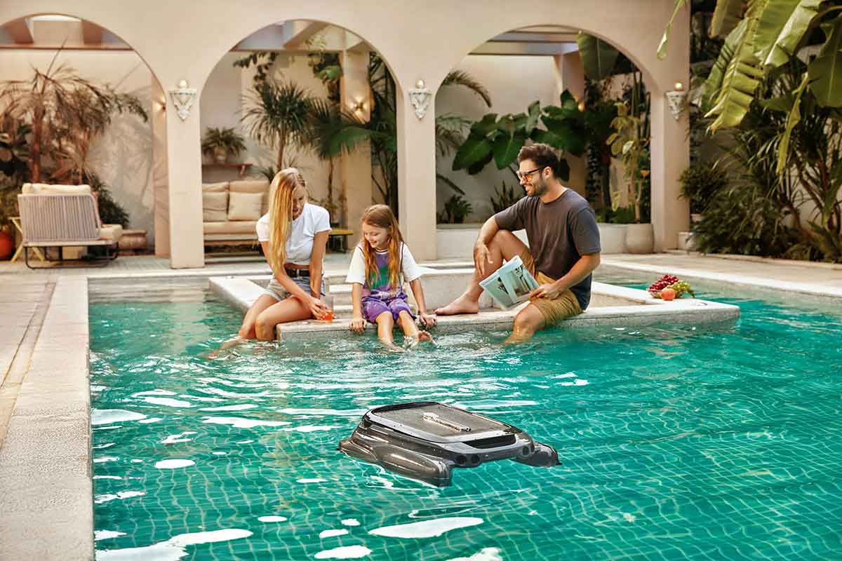 Cordless robotic pool vacuum cleaning an inground swimming pool