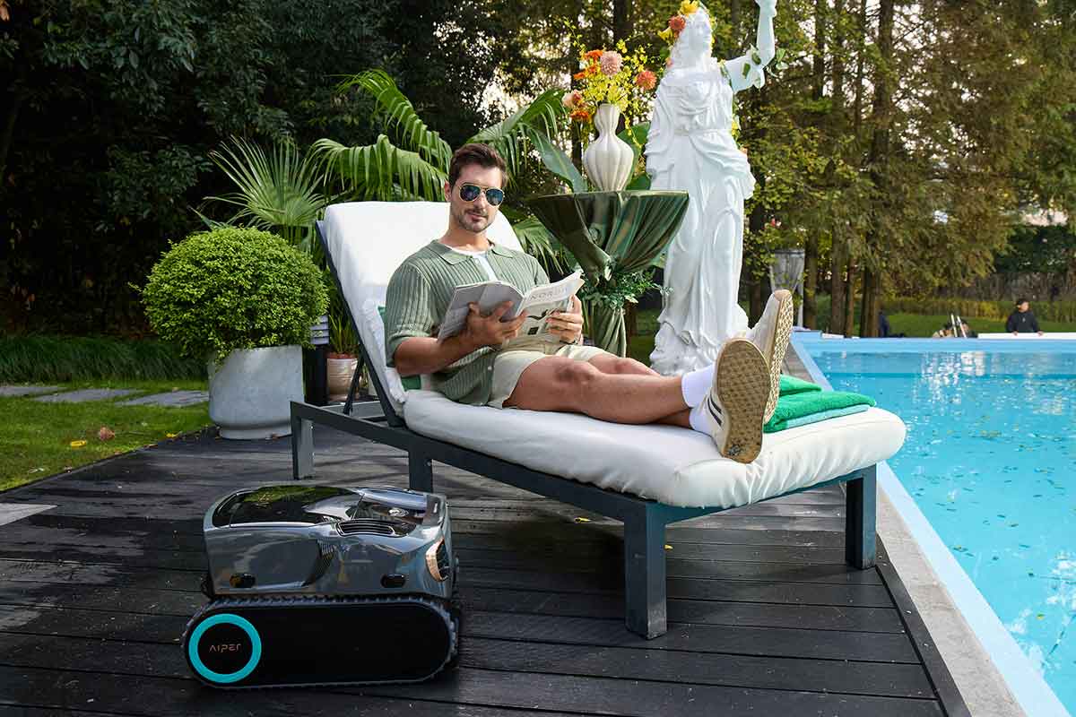 Robotic pool cleaning system traveling along an inground pool wall